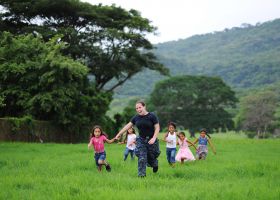 Nicaragua gringo woman running in a field with Nicaraguan children – Best Places In The World To Retire – International Living